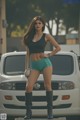 A woman standing in front of a white van.