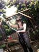 A woman holding a sword standing on a wooden deck.