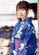 A woman in a blue and white kimono posing for a picture.