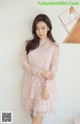 a woman wearing a pink dress with a long sleeve