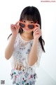 A young girl holding up a pair of heart shaped sunglasses.