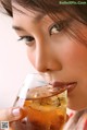 A woman is drinking a glass of iced tea.