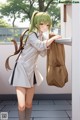 A girl in a school uniform holding a brown bag.