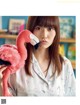 A woman holding a pink flamingo stuffed animal in her hand.