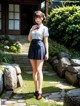 A woman in a school uniform standing in front of a house.